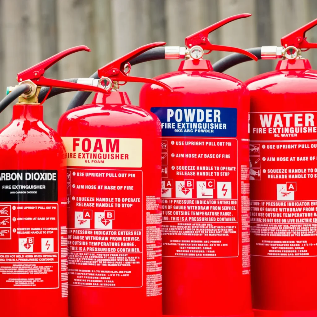 a setof four different type of fire extinguishers placed on a table with each others