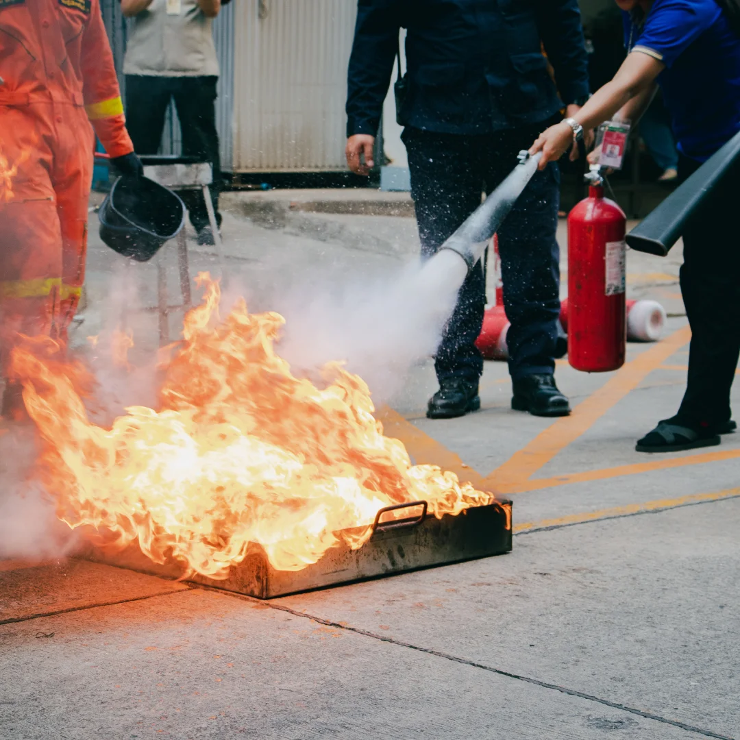 a team demonstrating a carbon die oxide based fire extinguisher on a fire